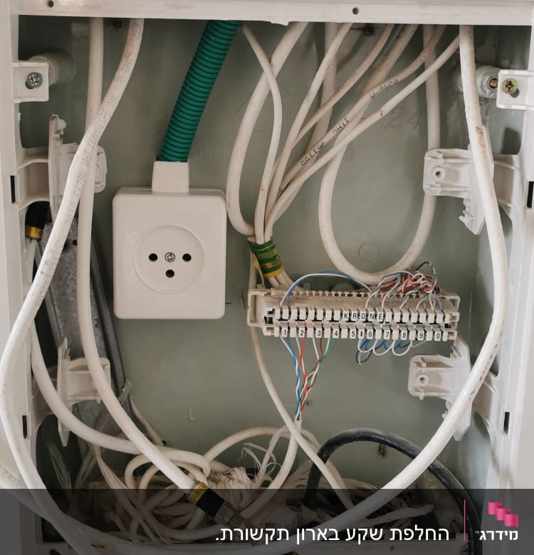 ארון חשמל פתוח עם חוטים ושקע חשמלי